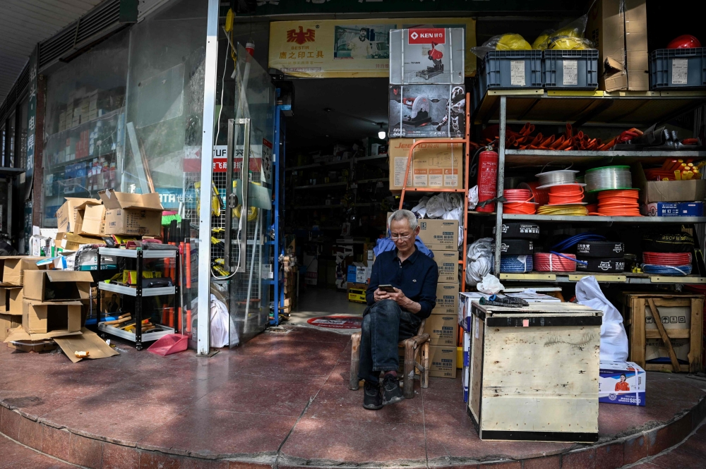 This photo taken on April 27, 2023 shows an elderly man sitting in front of a store in Rudong, in eastern China's Jiangsu province. — AFP pic