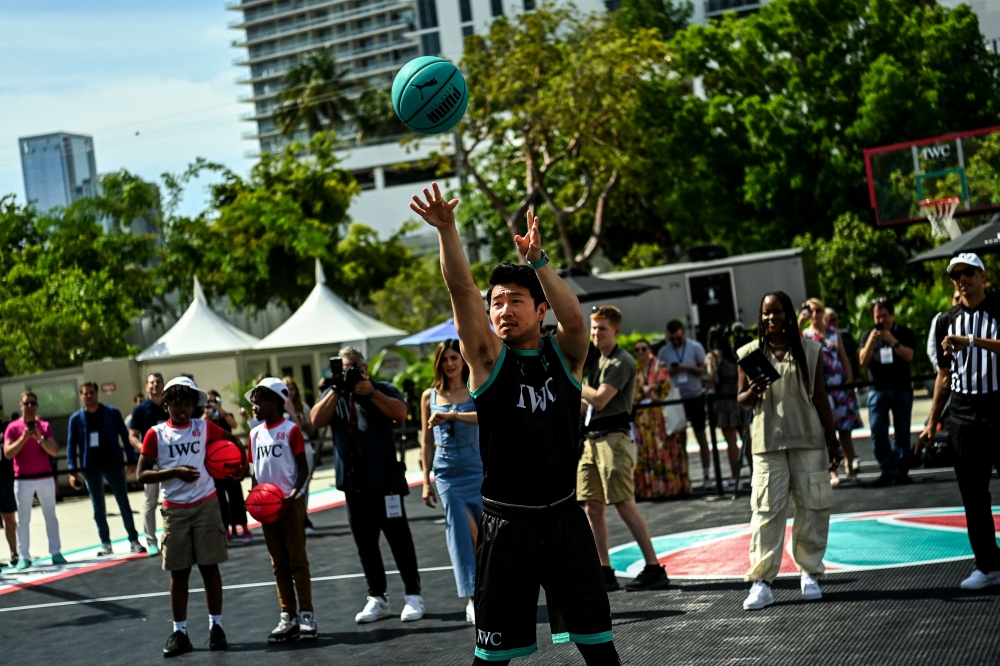 Canadian actor Simu Liu plays with a basketball during a IWC Schaffhausen basketball event ahead of the Miami Grand Prix in Miami. — AFP pic