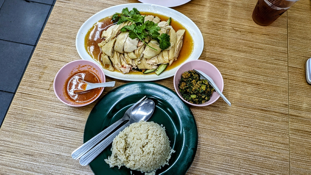 Lunch of champions with a plate of rice, poached chicken, ginger paste and chilli sauce.
