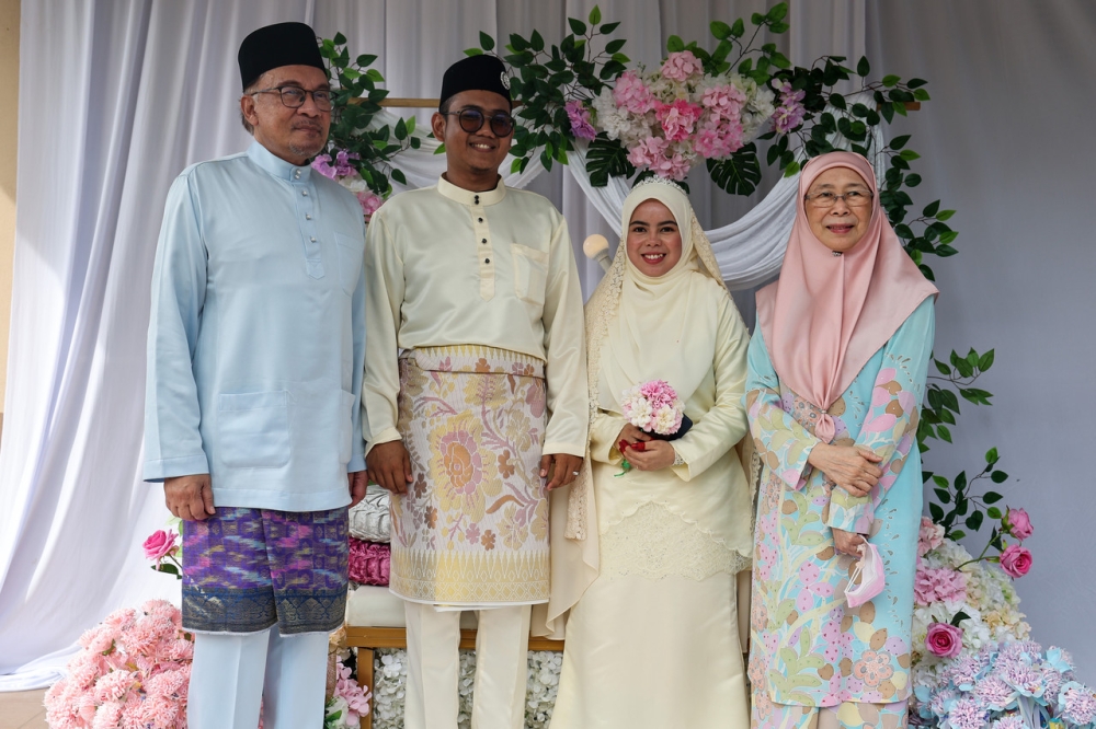 Prime Minister Datuk Seri Anwar Ibrahim and his wife, Datuk Seri Dr Wan Azizah Wan Ismail pose with the happy couple, Mohd Farhan Mohd Noor, 29, and Nurul Fateinul Ain Mazlan. — Bernama pic