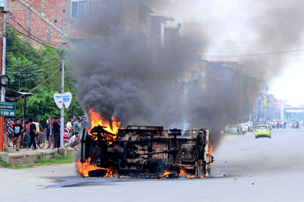 In this picture taken on May 4, 2023, smoke billows from a vehicle allegedly burned by the Meitei community tribals protesting to demand inclusion under the Scheduled Tribe category, in Imphal the capital of India's Manipur state. — AFP pic