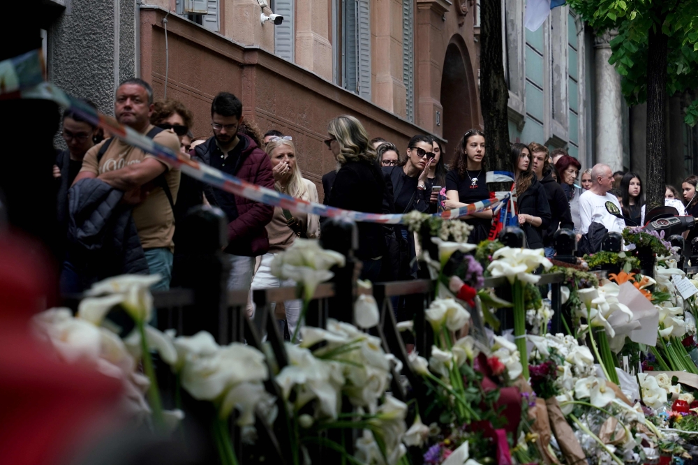 People line up to sign the book of condolences outside the Vladislav Ribnikar elementary school in the capital Belgrade, on May 4, 2023, two days after a 13-year-old suspect shot dead eight fellow students and a security guard after allegedly drawing up a kill list. — AFP pic
