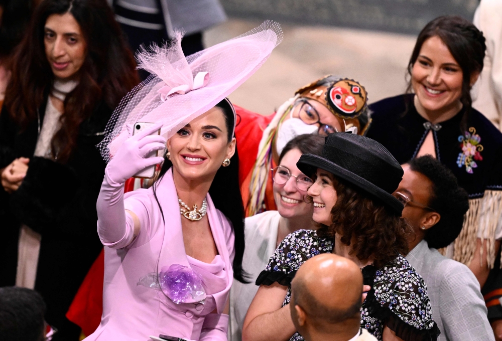 American singer-songwriter Katy Perry takes selfie photos with guests at Westminster Abbey in central London on May 6, 2023, during the coronations of Britain's King Charles III and Britain's Camilla, Queen Consort. — AFP pic
