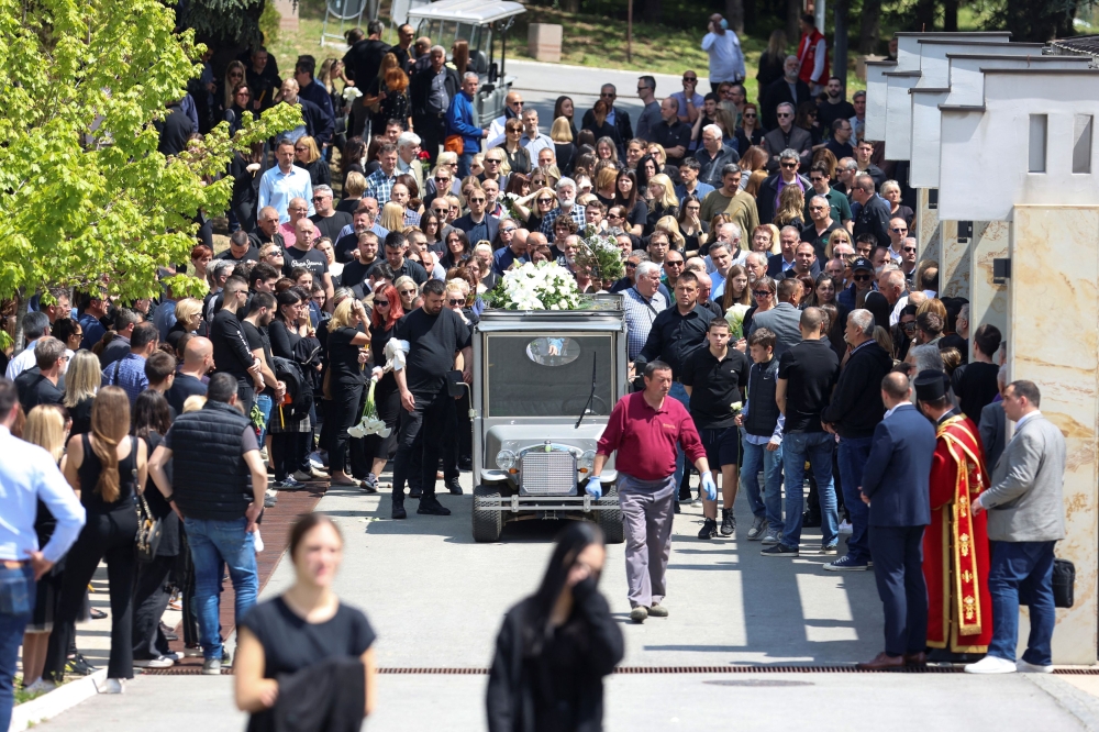 Burials were being held yesterday for four of the pupils and the guard killed in the school shooting and five young men killed in the second rampage. — Reuters pic