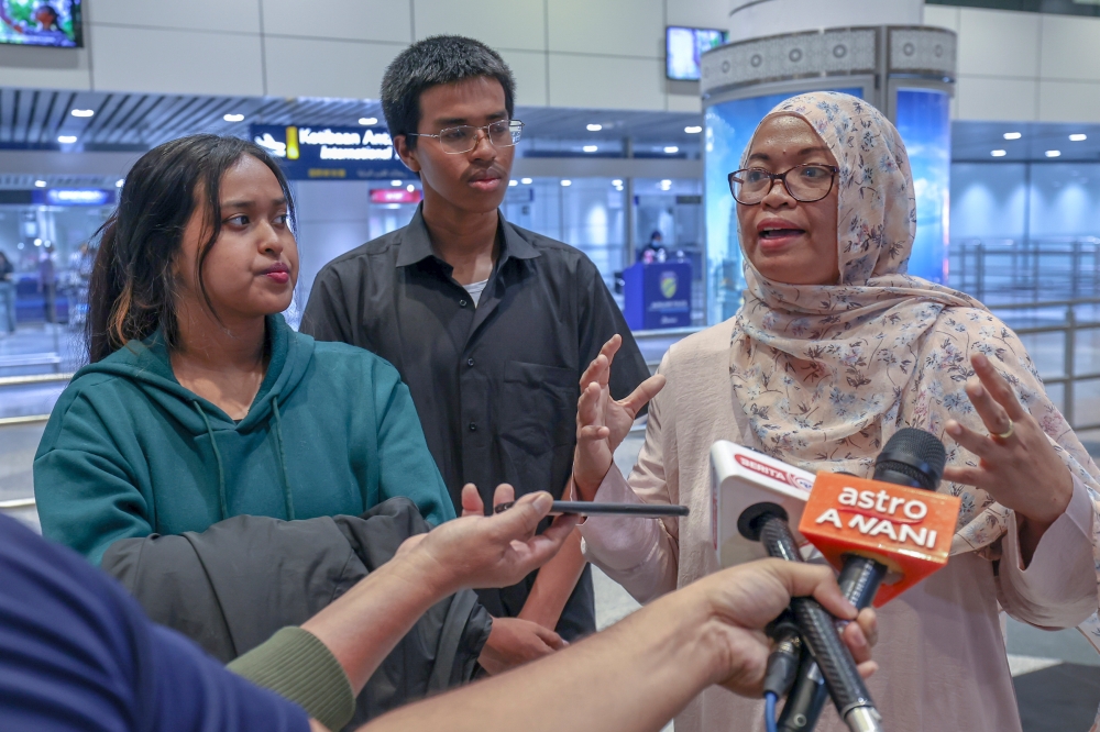 Junaidah Selamat, 49, son Mohamad Ashraf, 18, and daughter Juliana Ashraf, 23, arrived at the Kuala Lumpur International Airport (KLIA) here via Saudia flight SV842 which landed at 4.15am. — Bernama pic