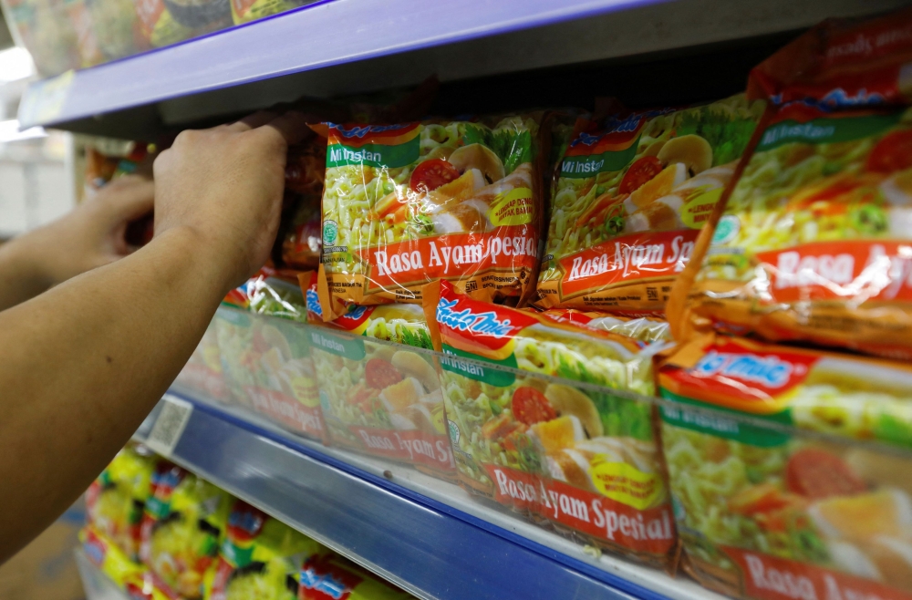 A worker arranges Indomie Special Chicken Flavour instant noodles packets, produced by PT Indofood Sukses Makmur, on the shelves of a supermarket in Jakarta, Indonesia April 26, 2023. — Reuters file pic