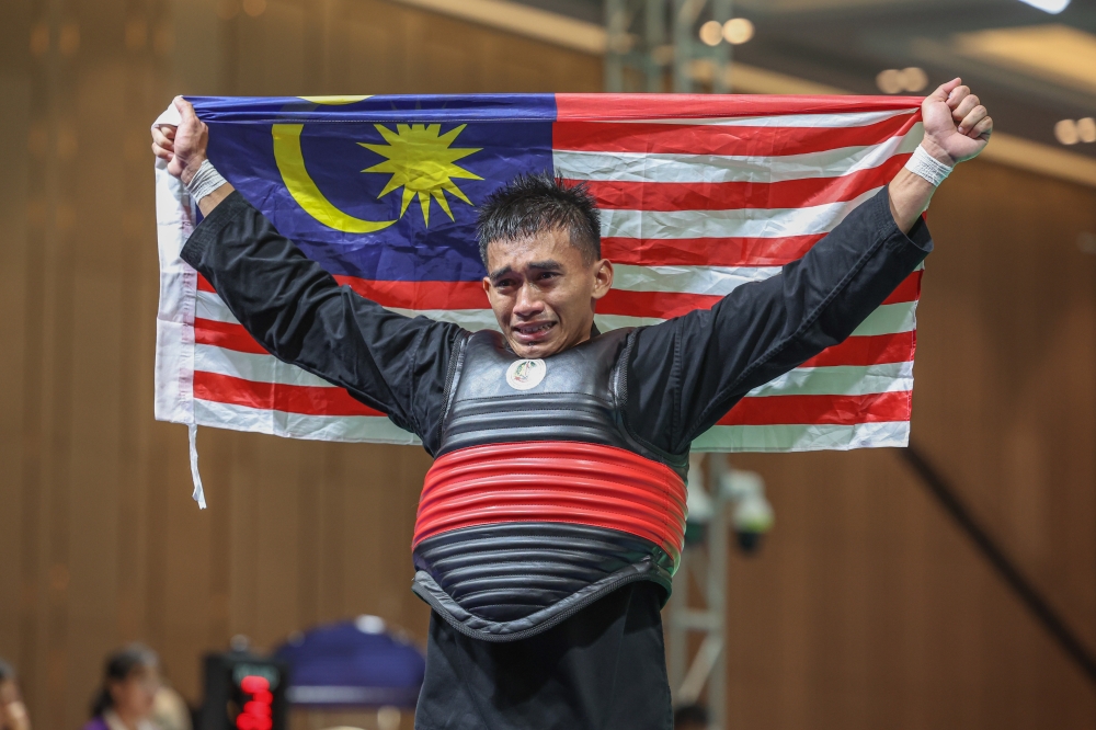 Malaysia’s Muhammad Izzul Irfan Marzuki poses with the Jalur Gemilang after defeating Indonesia’s Kadek Andrey Nova Prayada 39-33 in the Putra (men’s) 60-65kg category at the 2023 SEA Games at the Chroy Changvar Convention Centre, Phnom Penh May 10, 2023. — Bernama pic
