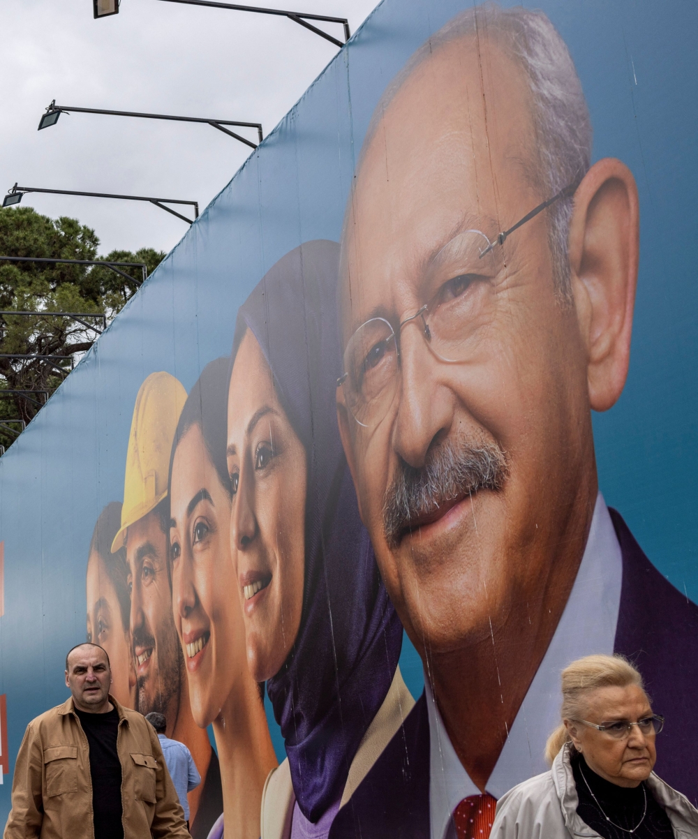People walk past an election banner of Kemal Kilicdaroglu, presidential candidate of Turkey's main opposition alliance, ahead of the May 14 presidential and parliamentary elections, in Istanbul, Turkey May 10, 2023. — Reuters pic