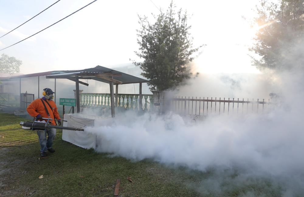 An Ipoh city council worker is seen fogging drains in Taman Meru, Ipoh March 27, 2018. — Picture by Farhan Najib