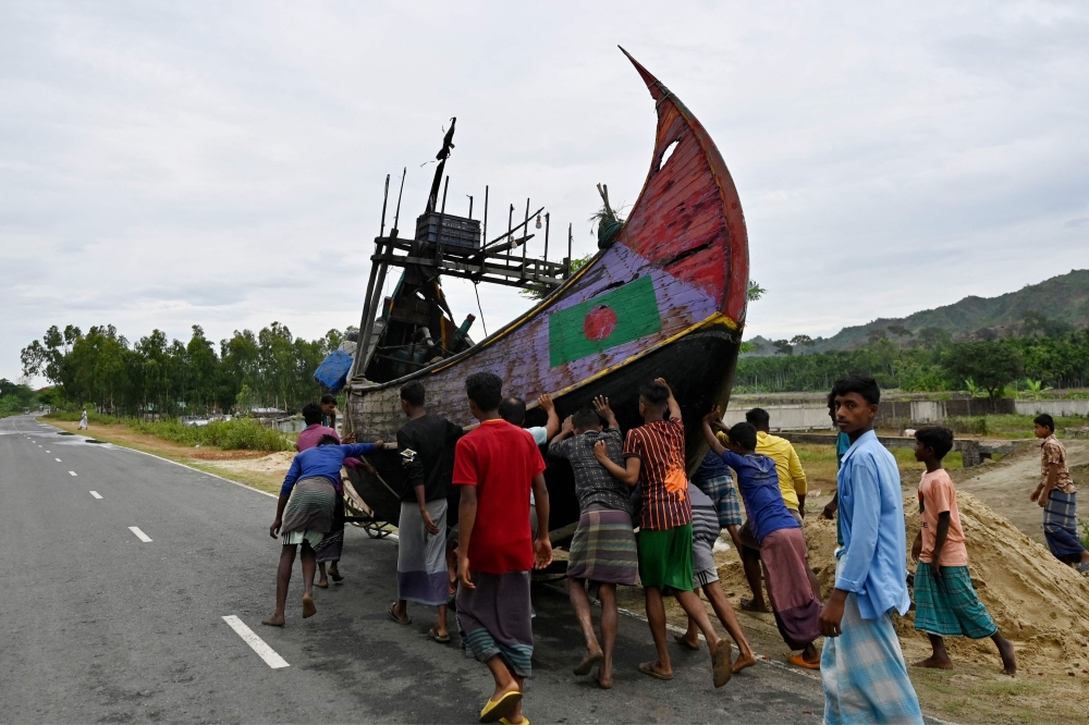 Fishermen shift a boat to a safer place in Teknaf, ahead of Cyclone Mocha  landfall May 13, 2023. — AFP pic