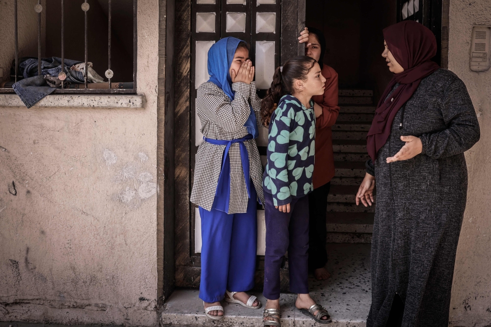 Children react following an Israeli air strike in Beit Lahia in the northern Gaza Strip, on May 13, 2023. — AFP pic