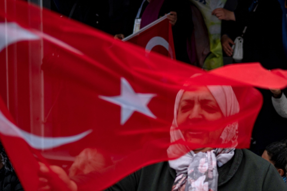 A supporter of Turkish President and leader of the Justice and Development (AK) Party, Recep Tayyip Erdogan waves national flags during an election campaign in Istanbul on May 12, 2023, ahead of the May 14 presidential and parliamentary elections. — AFP pic