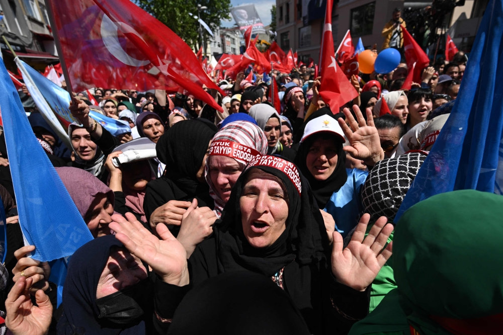 Supporters of the incumbent Turkish President, who runs for re-election, gesture and cheer as they gather for a rally in the Beyoglu district on the eve of the presidential and parliamentary elections, on the European side of Istanbul, on May 13, 2023. — AFP pic