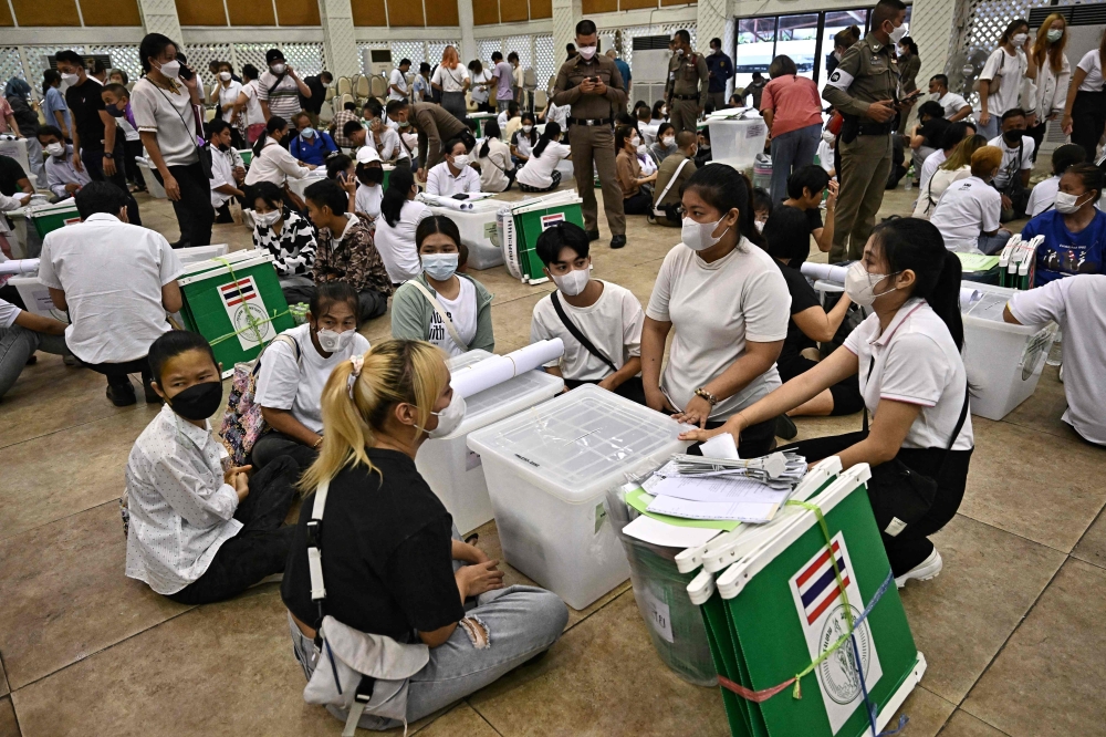 Election Commission volunteers inspect ballots and voting materials for distribution to polling booths. — AFP pic