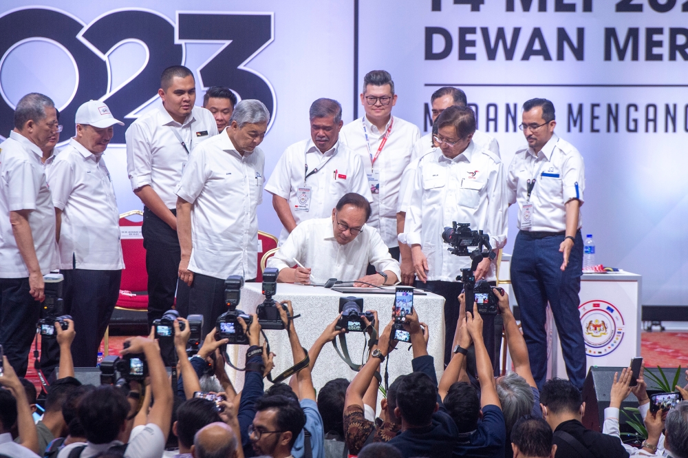Pakatan Harapan chairman Datuk Seri Anwar Ibrahim signs the unity government resolution Unity Government National Convention at World Trade Centre Kuala Lumpur May 14, 2023. — Picture by Shafwan Zaidon