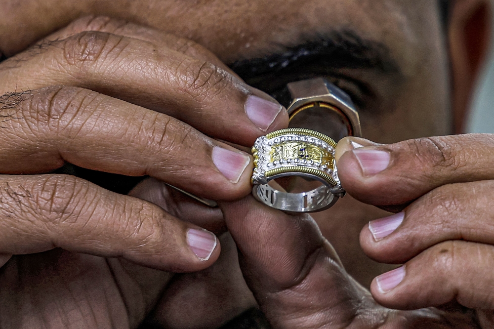 In this picture taken on February 19, 2023 a smith uses a loupe magnifier to inspect a jewellery piece at the Azza Fahmy workshop in the 6th of October industrial zone southwest of Egypt's capital. — AFP pic