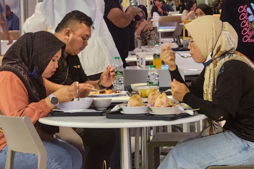 Roslina Farhan, 32 and her colleagues are seen eating 