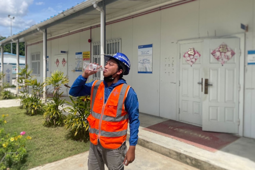 A construction site worker in Tunjong near Kota Baru, Kelantan drinks water during his shift. May 19, 2023. — Picture by Muhammad Yusry
