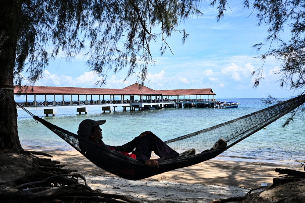 A tourist is seen relaxing in a hammock in Pulau Bidong May 20, 2023. — Bernama pic