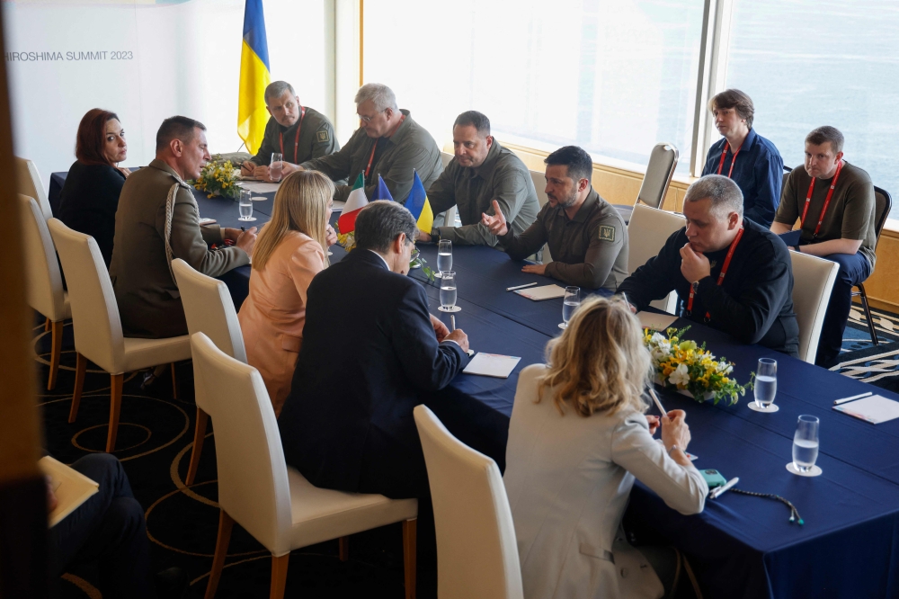 Ukraine’s President Volodymyr Zelensky (centre right) speaks with Italy’s Prime Minister Giorgia Meloni (centre left) during their bilateral meeting on the sidelines of the G7 Leaders’ Summit in Hiroshima on May 20, 2023. ― AFP pic