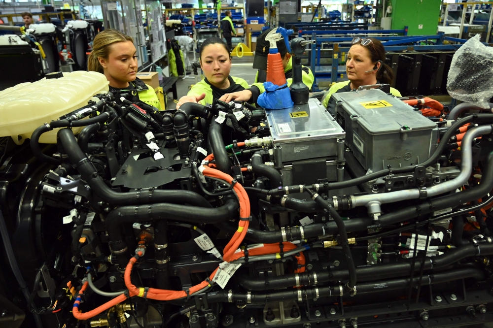 Employees assembling an electric truck engine on the assembly line at the Volvo plant in Gothenburg, Sweden. — AFP pic