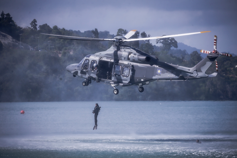 Special Naval Team (Paskal) combat swimmers are seen dropping into the water from the Royal Malaysian Navy (RMN) AW139 maritime operations helicopter at the launch of Lima 2023 in Resort World Langkawi May 23, 2023. — Picture by Hari Anggara