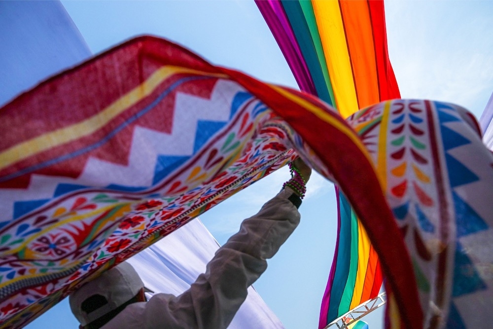A member of the lesbian, gay, bisexual, and transgender (LGBT) community holds a colourful scarf under a rainbow flag during the Pride Boat Parade, an event of the Myanmar's Yangon Pride festival in Yangon January 26, 2018. — AFP pic