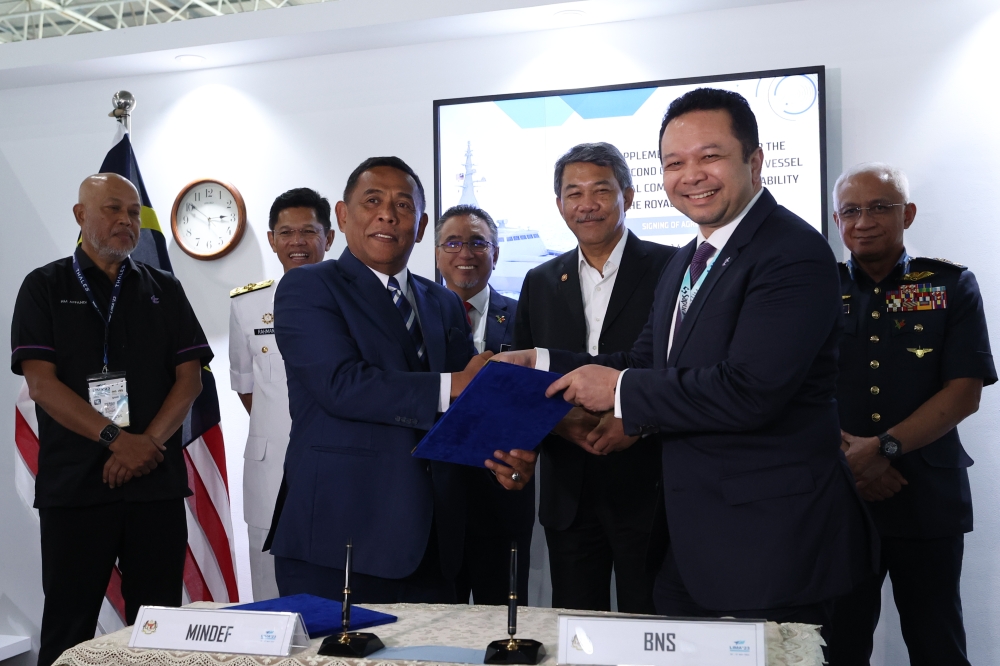  Defence Minister Datuk Seri Mohamad Hasan witnesses the signing of the sixth supplementary contract on the littoral combat ships project between Defence Ministry secretary-general Datuk Seri Muez Abd Aziz and Boustead Holding Bhd chairman Datuk Nazim Rahman (2nd right) at the Langkawi International Maritime and Aerospace exhibition in Langkawi May 26, 2023. — Bernama pic
