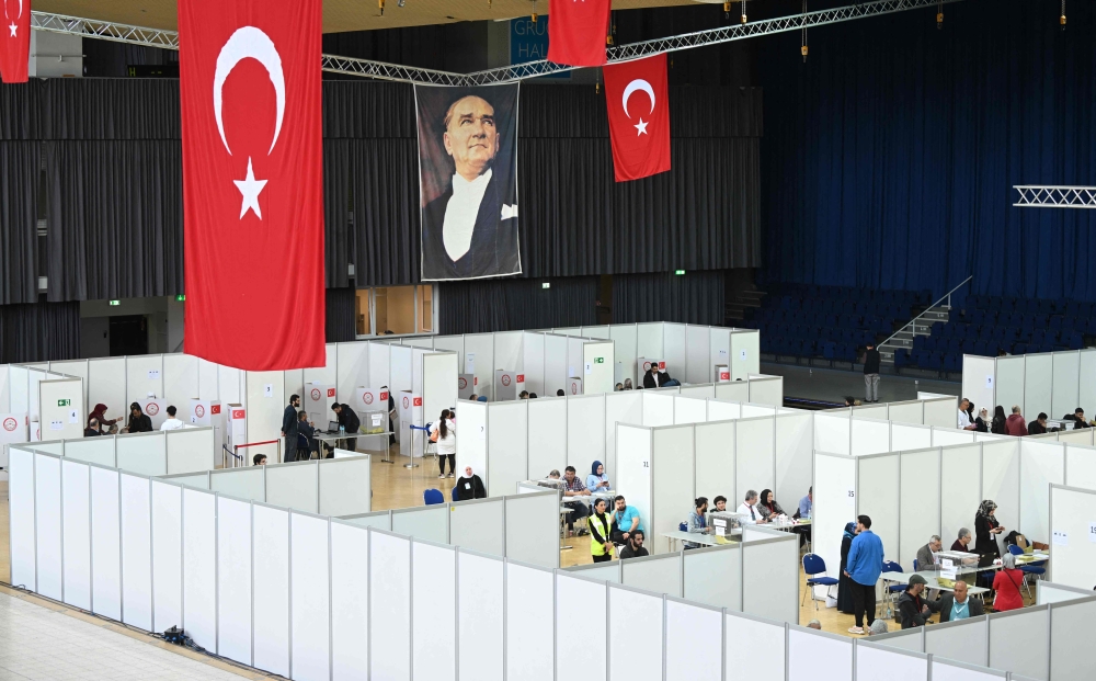 A portrait of Mustafa Kemal Ataturk, founding father of the Republic of Turkey, is fixed next to Turkish flags at a polling station set up in the Grugahalle hall in Essen, western Germany, on May 23, 2023, ahead of Turkey’s first run-off election to take place on May 28, 2023. — AFP pic