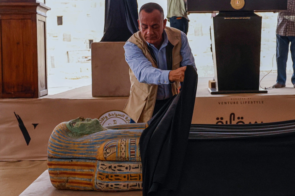 Mostafa Waziri, head of Egypt's Supreme Council of Antiquities, unveils a sarcophagus in the Saqqara necropolis, where archaeologists unearthed two human and animal embalming workshops as well as two tombs, south of Cairo on May 27, 2023. — AFP pic