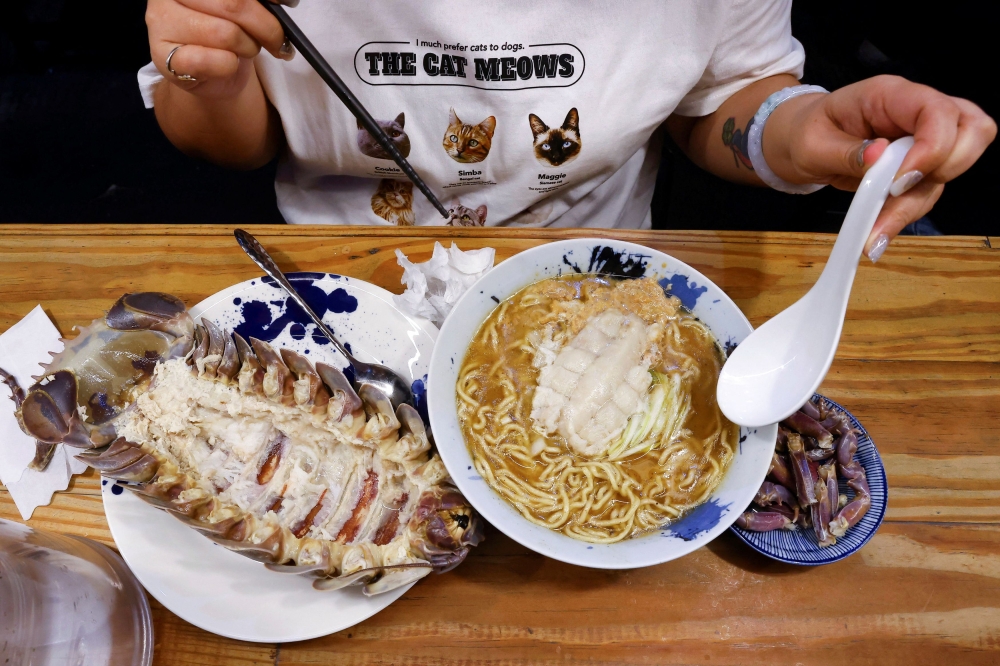 Digell Huang, 34, one of the two reserved customers tries the giant isopod ramen in Taipei, Taiwan May 27, 2023. — Reuters pic