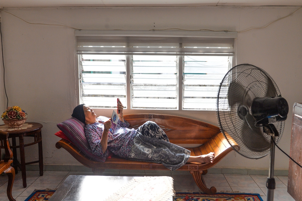 A housewive, Kamisah, stays inside the house with the fan turned on due to the prolonged hot weather in Shah Alam May 25,2023. — Picture by Miera Zulyana