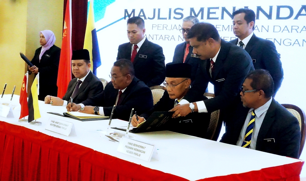 Kedah Menteri Besar Datuk Seri Muhammad Sanusi Md Nor (3rd left) and Perlis Menteri Besar Mohd Shukri Ramli (3rd right) ink the land and maritime boundary agreement between Kedah and Perlis at Wisma Darul Aman, Alor Setar May 29, 2023. — Bernama pic