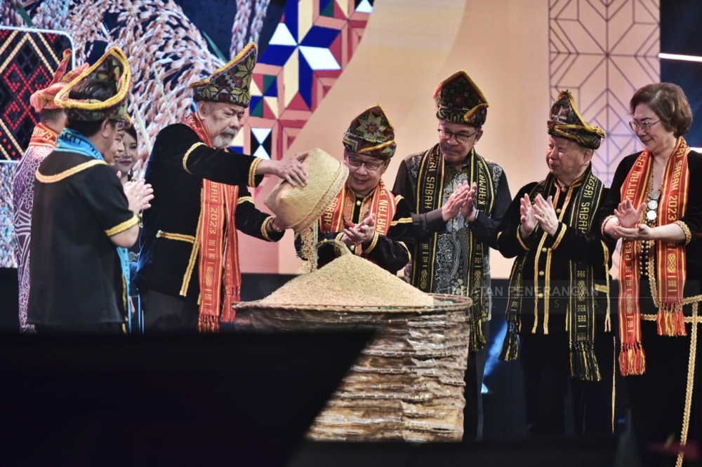 Prime Minister Datuk Seri Anwar Ibrahim (third from right) watches as Head of State Tun Juhar Mahiruddin pours some freshly harvested rice into a traditional 'tangkob' during the closing ceremony of the Kaamatan festival in Kota Kinabalu May 31, 2023. — Picture courtesy of Information Department