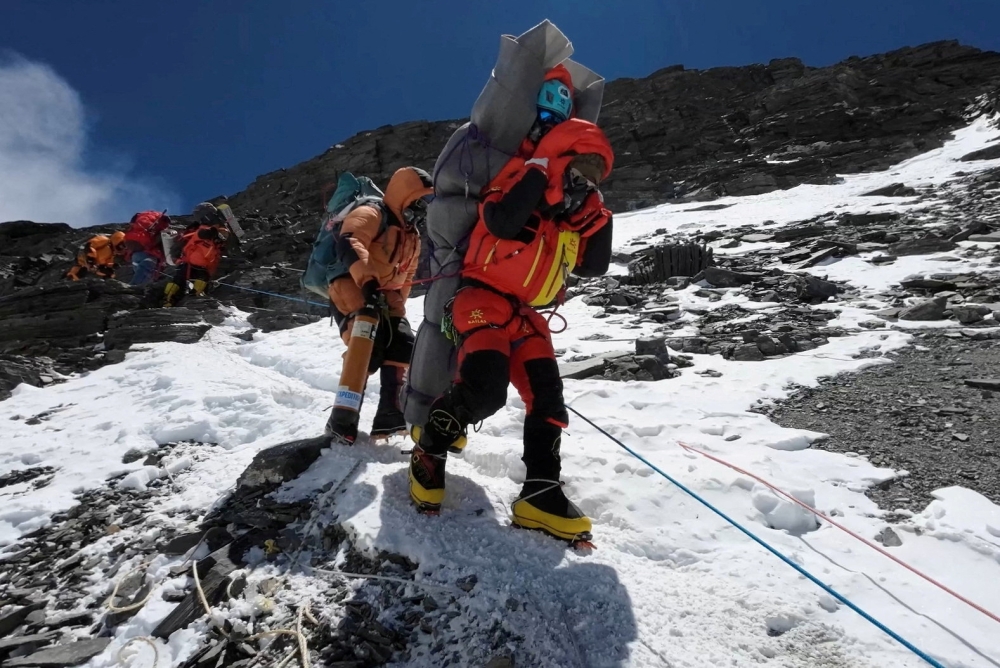 Ngima Tashi Sherpa walks as he carries a Malaysian climber while rescuing him from the death zone above camp four at Everest, Nepal, May 18, 2023 in this screengrab obtained from a handout video.  ― Gelje Sherpa/Handout via Reuters