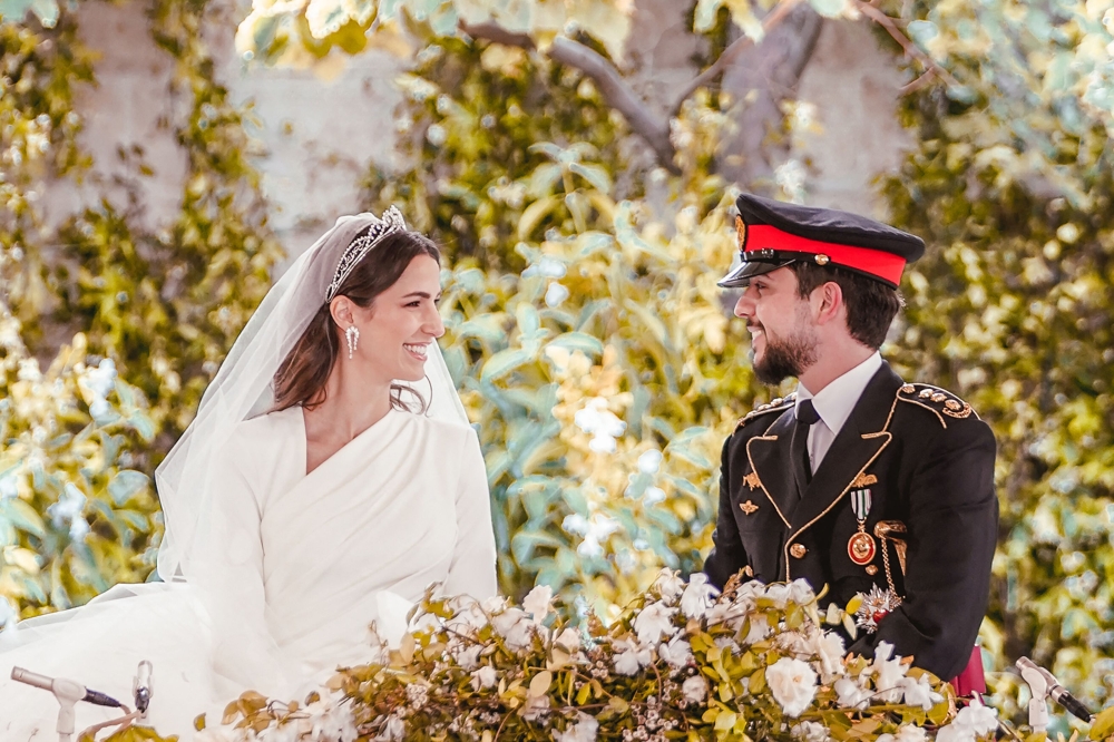 A handout picture from the Jordanian Royal Palace shows Crown Prince Hussein (R) and his wife Saudi Rajwa al-Seif sitting during their wedding ceremony at the Zahran Palace in Amman on June 1, 2023. — Jordanian Royal Palace / AFP pic