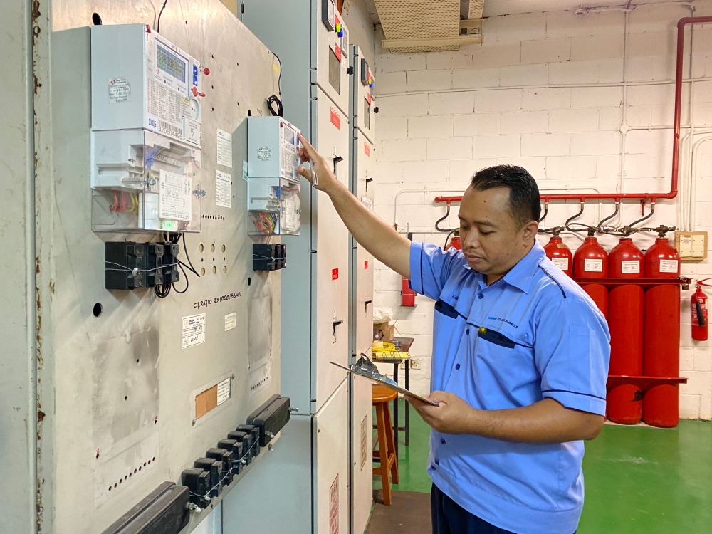 Mohd Azamri bin Nazar performs daily power checks at the Sunway College low voltage room. — Picture by Jared Wee