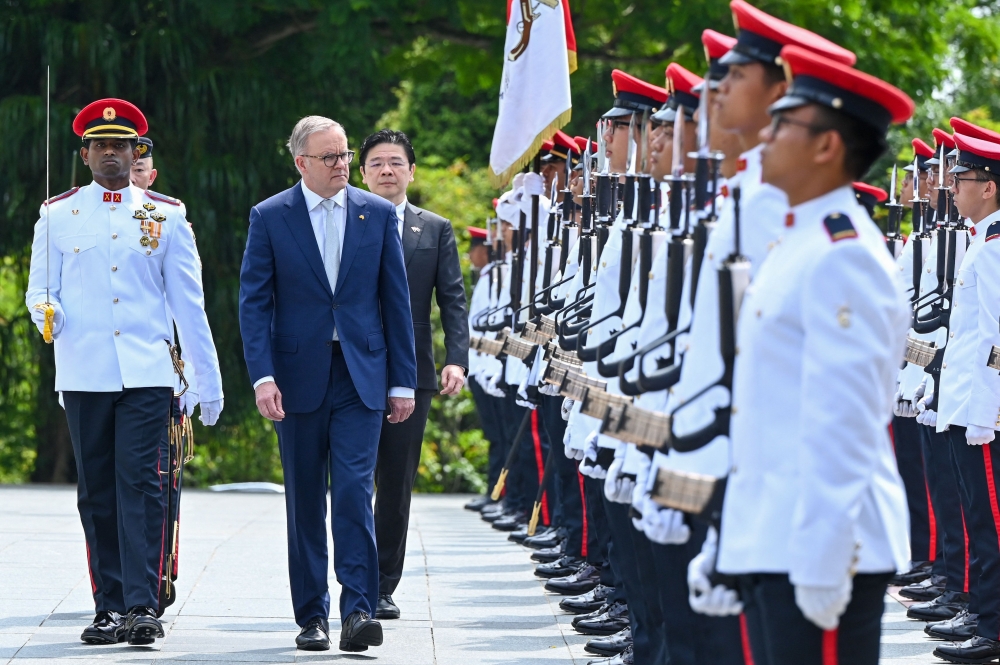 Australia's Prime Minister Anthony Albanese (2nd left) and Singapore's Deputy Prime Minister Lawrence Wong (back centre) walk past a guard of honour during a welcome ceremony at Istana presidential palace in Singapore June 2, 2023. — Roslan Rahman/Pool/AFP pic