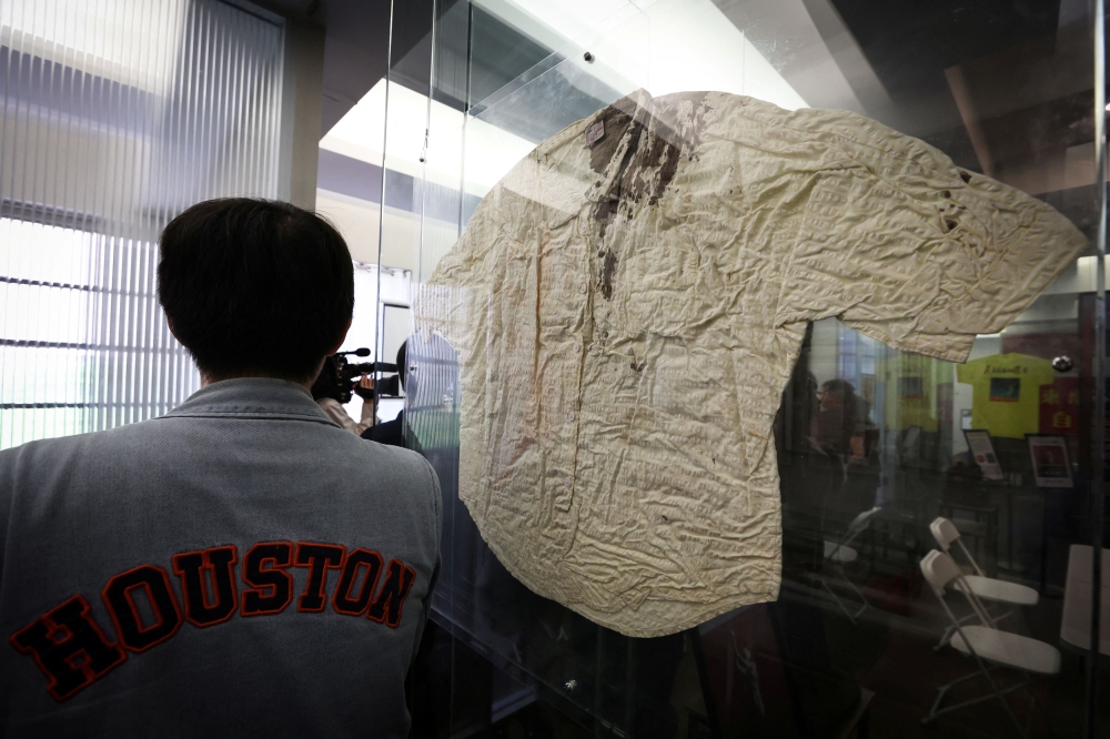 A man stands next to the blood stained shirt of Jiang Lin, a reporter for the army newspaper who was bloodied by police with electric prods in Tiananmen Square China on June 3 during the uprising in 1989, during a press preview of the Tiananmen June 4th Memorial permanent exhibition museum which opens June 2 in Manhattan, in New York City June 1, 2023. — Reuters pic