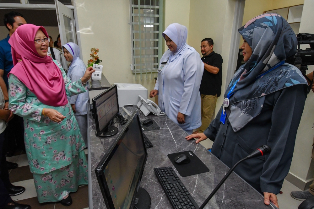 Health Minister Dr Zaliha Mustafa (left) visits the inquiry counter after witnessing the handing over of the Type 7 Health Clinic Project at the Ayer Eye Health Clinic in Machang, Kelantan. — Bernama pic 