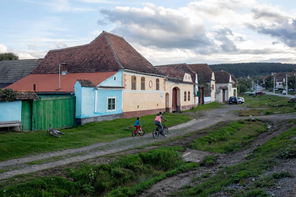 Two kids ride bikes on the main street of Viscri, where King Charles III’s foundation owns a property, in Transylvania, central Romania, on September 13, 2022. — AFP pic 