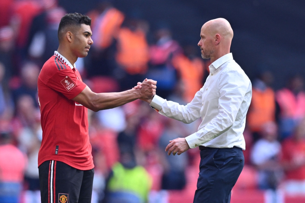 Manchester United's Dutch manager Erik ten Hag consoles Manchester United's Brazilian midfielder Casemiro on the pitch after the English FA Cup final football match between Manchester City and Manchester United at Wembley stadium, in London, on June 3, 2023. — AFP pic