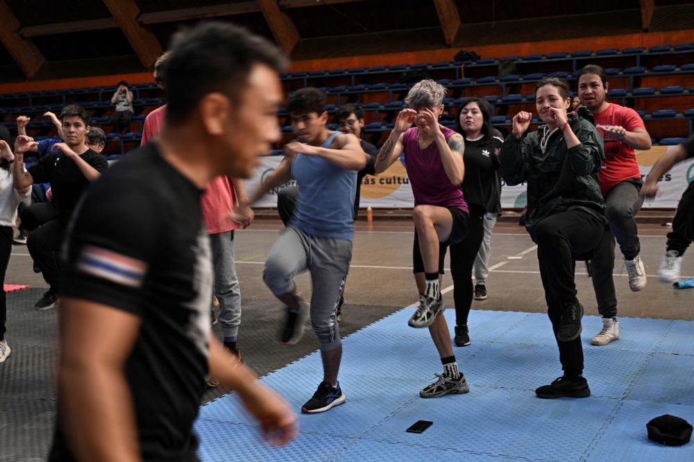 Muay Thai master Kru Din (Wittawat Kasom) (foreground) teaches Lanna Fighting Muaythai, during a Thai boxing self-defence workshop for members of the LGBTIQ+ community, in the municipality of Cerro Navia, Santiago, on May 27, 2023. — AFP pic