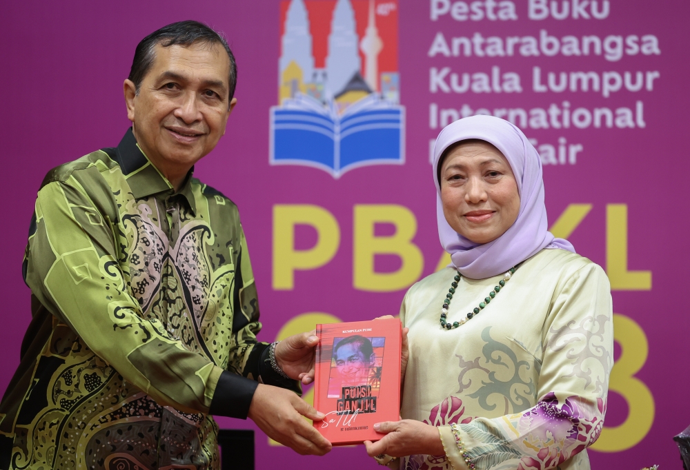 Women, Family and Community Development Minister Datuk Seri Nancy Shukri receives a copy of the ‘Puisi Ganjil: SaTU!’ at the launch of the book at the 2023 Kuala Lumpur International Book Fair, Kuala Lumpur June 4, 2023. — Bernama pic