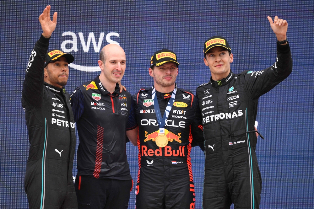 First placed Red Bull's Dutch driver Max Verstappen (second from right), second placed Mercedes' British driver Lewis Hamilton (centre) and third placed Mercedes' British driver George Russell (right) celebrate on the podium after the Spanish Formula One Grand Prix race at the Circuit de Catalunya in Montmelo June 4, 2023. — AFP pic