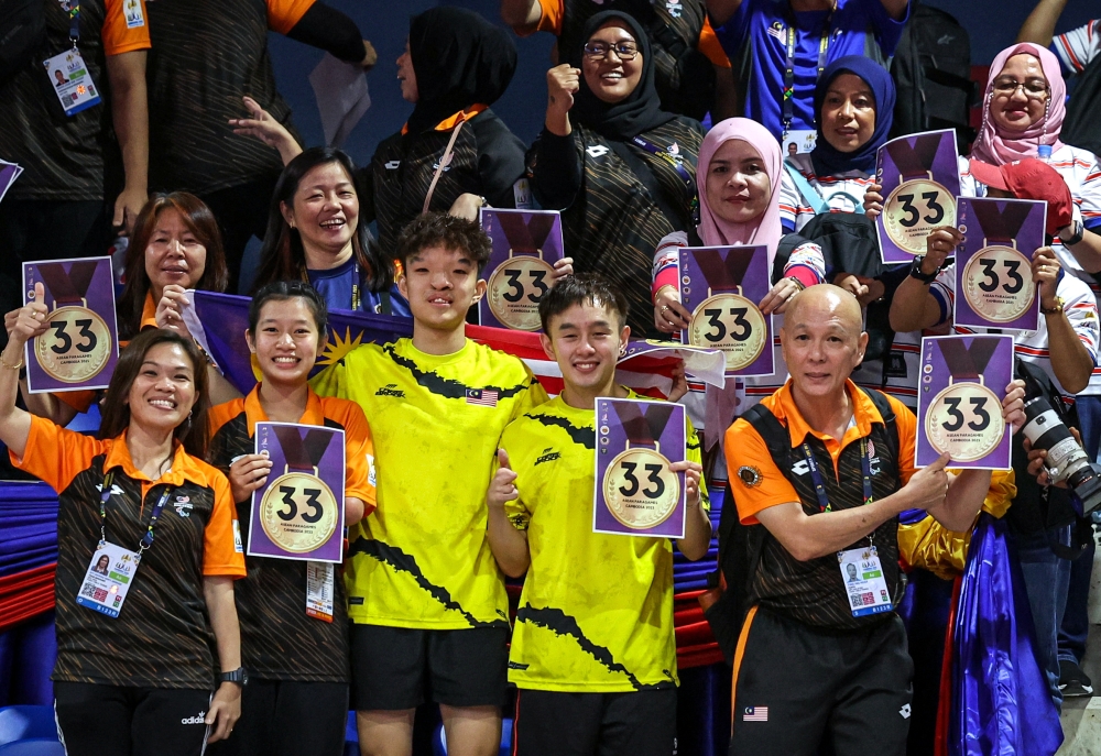 Malaysian supporters with their ‘33 Golds’ poster as Chee Chaoming and Brady Chin win the gold medal in the Men’s Team Class 9 event at the Table Tennis Hall, Morodok Techo Stadium, Phnom Penh, June 6, 2023. — Bernama pic 