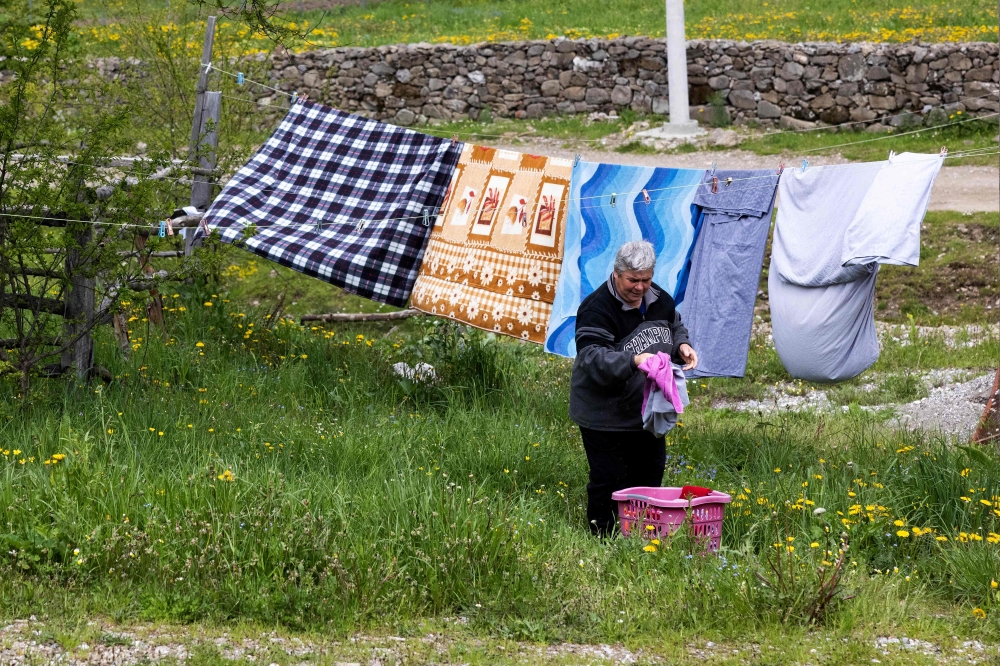 Grisha collects laundry at her home in the mountain village of Lepushe. — AFP pic