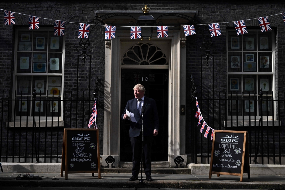 In this file photo taken on May 9, 2022 Britain's then prime minister Boris Johnson looks up as he delivers a speech in front of 10 Downing Street in central London for the launching of the street market Downing street Spring Showcase. — AFP pic