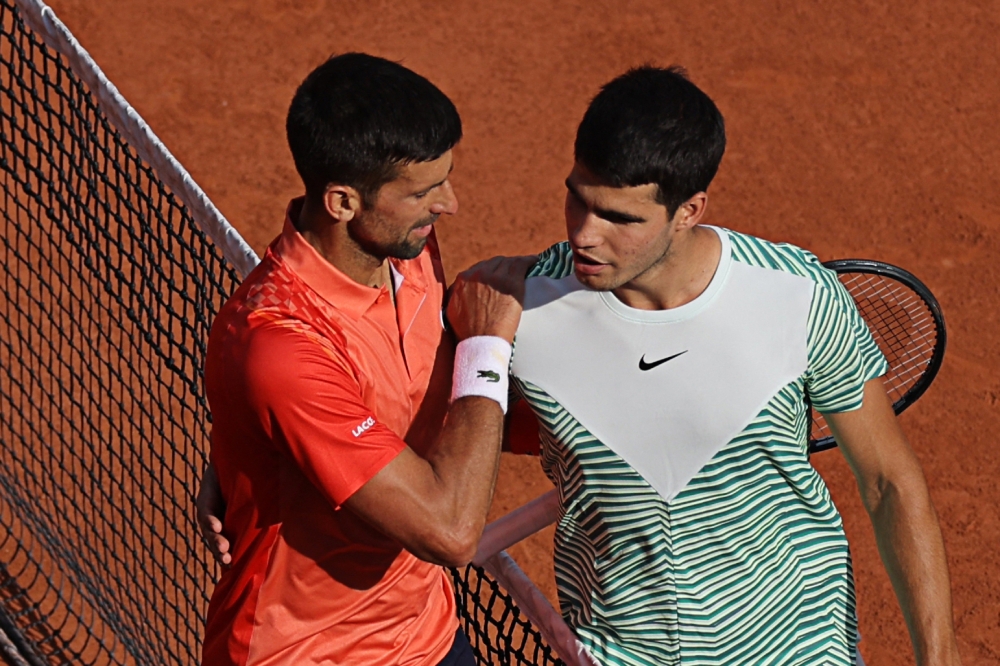 Serbia’s Novak Djokovic (left) comforts Spain’s Carlos Alcaraz Garfia after his victory during their men’s singles semi-final match on day thirteen of the Roland-Garros Open tennis tournament at the Court Philippe-Chatrier in Paris on June 9, 2023. — AFP pic