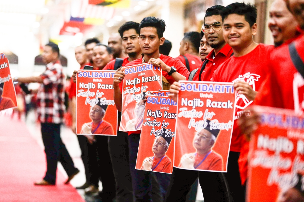 Umno members are seen holding ‘Solidarity for Najib Razak’ posters during the opening of the 2023 Umno General Assembly at the World Trade Centre in Kuala Lumpur June 9, 2023. — Picture by Sayuti Zainudin